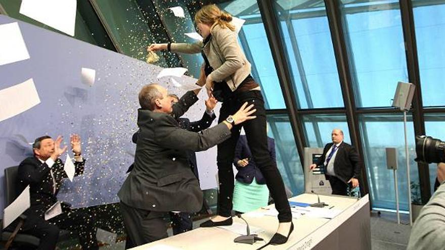 Una joven interrumpe la rueda de prensa de Draghi al saltar sobre su mesa y lanzarle confeti