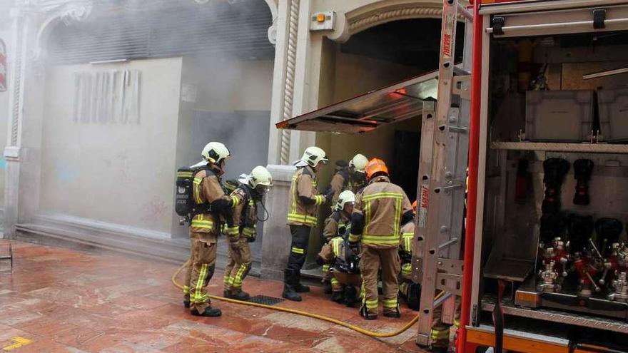 Los bomberos realizando labores de ventilación, ayer, a la entrada de la discoteca.