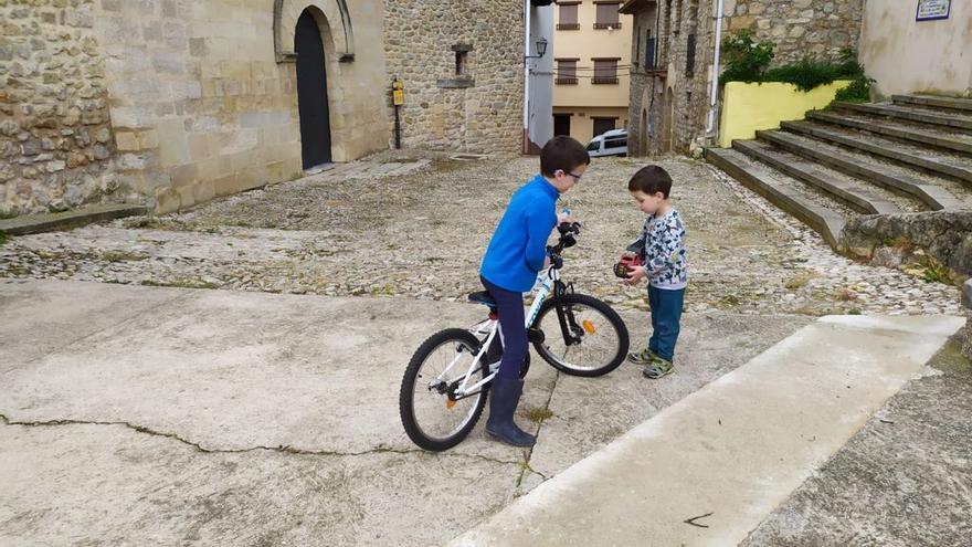 Dos niños juegan en una plaza de Herbers, imagen cada vez menos habitual en el Castellón del interior.