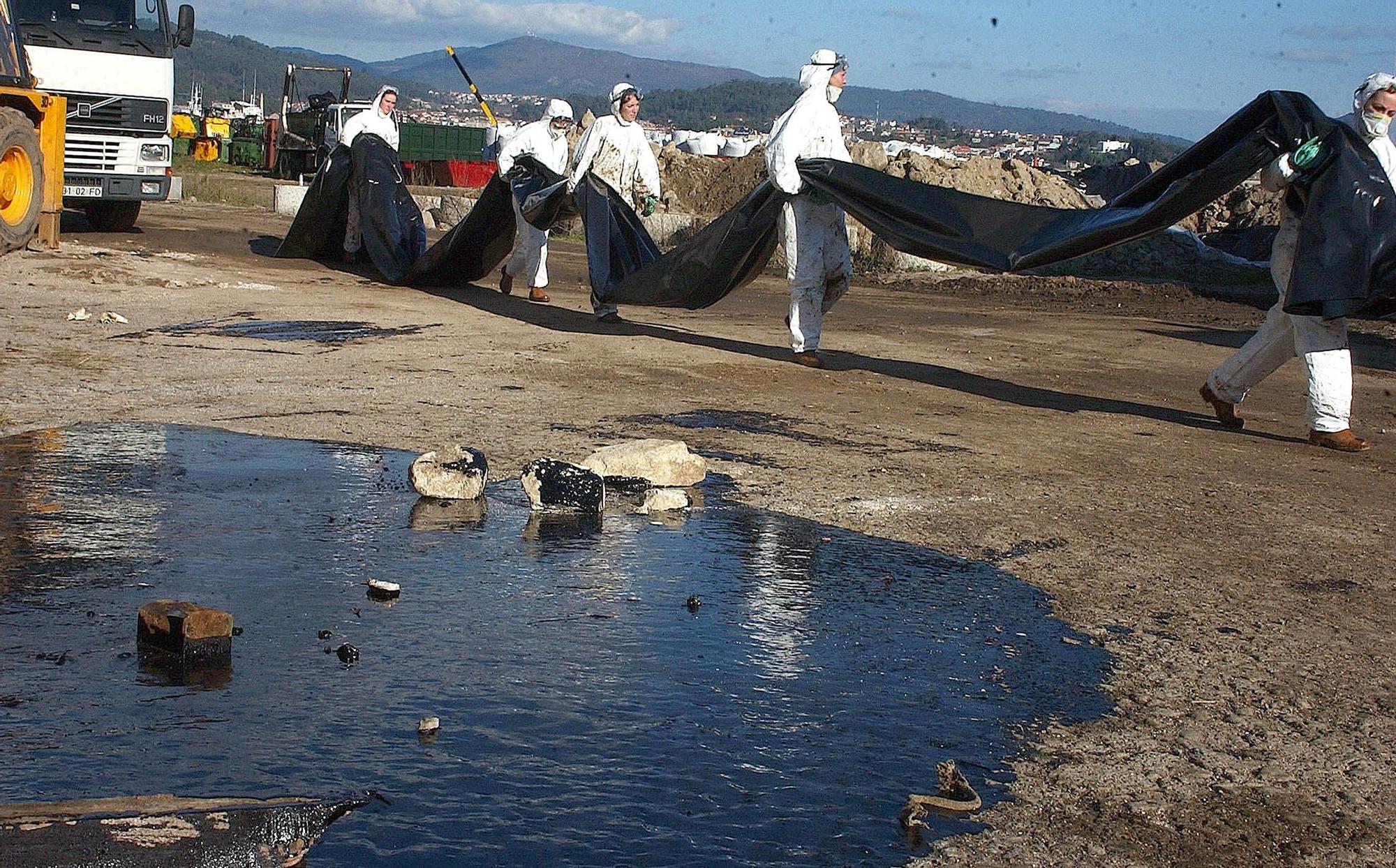 Tareas de recogida del chapapote en la zona de Massó en Cangas.