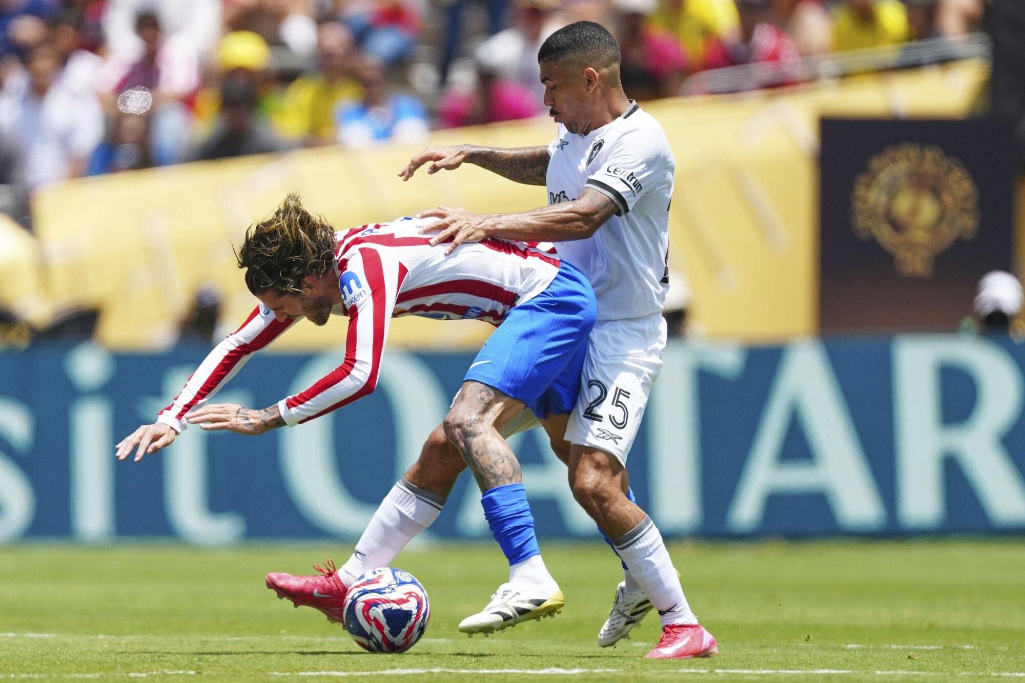 Atletico Madrid's Rodrigo De Paul, left, and Botafogo's Allan battle for the ball during the Club World Cup Group B soccer match between Atletico Madrid and Botafogo in Pasadena, Calif., Monday, June 23, 2025. (AP Photo/Jae Hong)