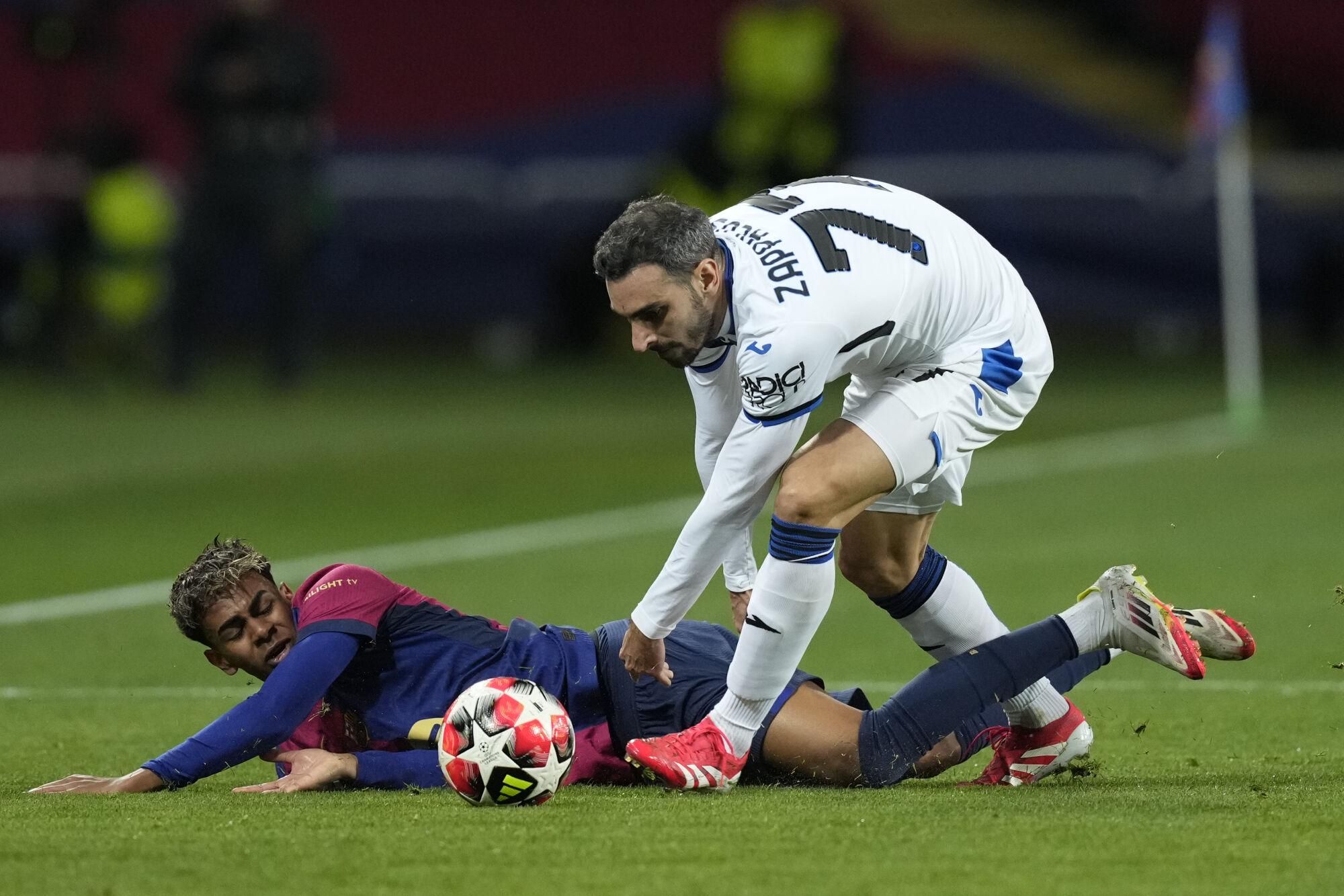 BARCELONA, 29/01/2025.- El delantero del FC Barcelona Lamine Yamal (i) cae junto a Davide Zappacosta, del Atalanta, durante el partido de la Liga de Campeones de la UEFA que FC Barcelona y Atalanta BC disputan este miércoles en el estadio Olímpico Lluís Companys. EFE/ Enric Fontcuberta