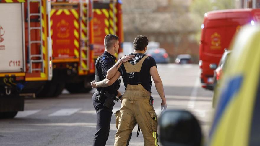 Un agente consuela a un bombero tras la tragedia de Alcorcón.