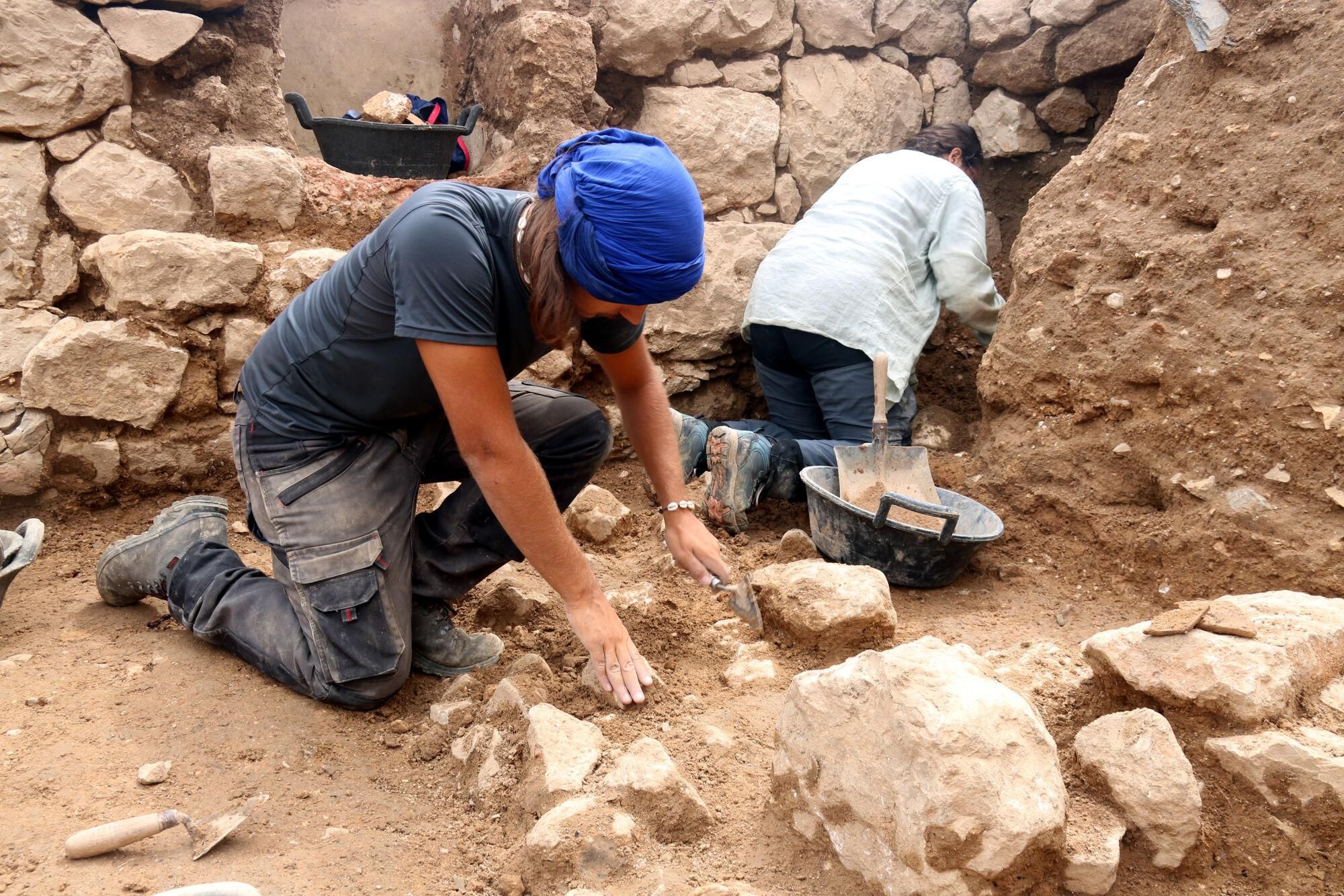 Un arqueòleg excavant a la zona de la terrassa superior que envoltaria l'antic santuari dedicat a la deessa Demèter a Empúries