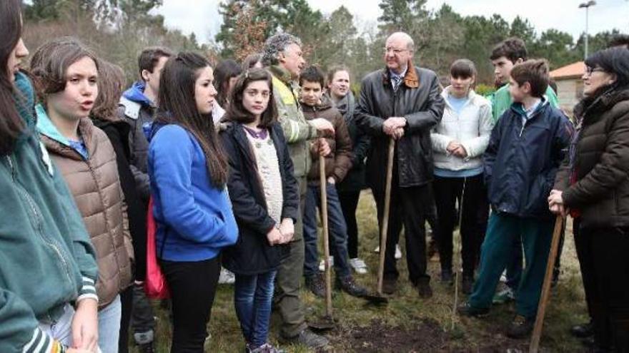 El alcalde Agustín Fernández (centro) y la edil de Medio Ambiente, Susana Bayo (1ª drcha.), junto a alumnos de Bachillerato en la plantación  de árboles.   // Iñaki Osorio