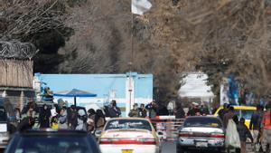 Mujeres afganas en la puerta de la universidad, custodiada por soldados, en Kabul.