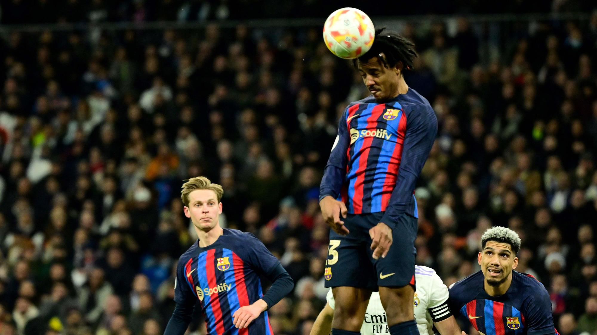 Koundé despeja un balón aéreo durante el Madrid-Barça copero en el Bernabéu.
