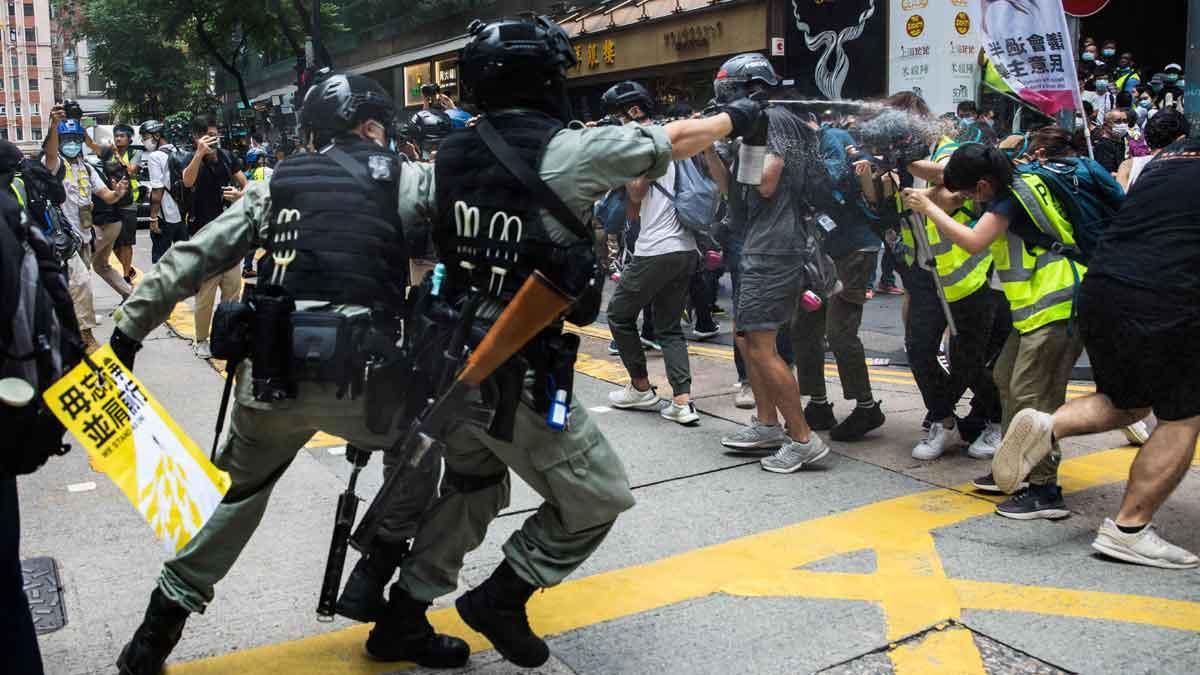 Nuevas protestas contra la ley de seguridad en Hong Kong. En la foto, policías antidisturbios lanzan gas pimienta contra periodistas durante las protestas.