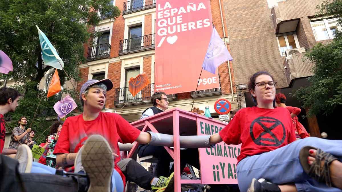 Miembros de una entidad ecologista se encadenan frente a la sede del PSOE en Madrid