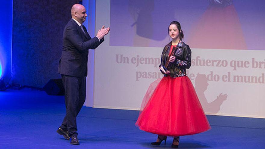 El director de INFORMACIÓN, Tomás Mayoral, aplaude a la modelo Marián Ávila tras entregarle el galardón.