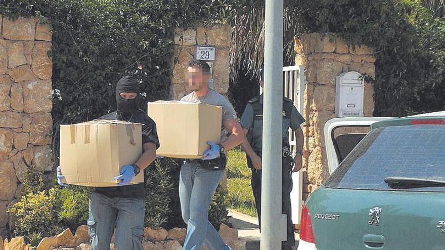 Agentes de la Guardia Civil sacan cajas con documentación en uno de los registros durante la redada.