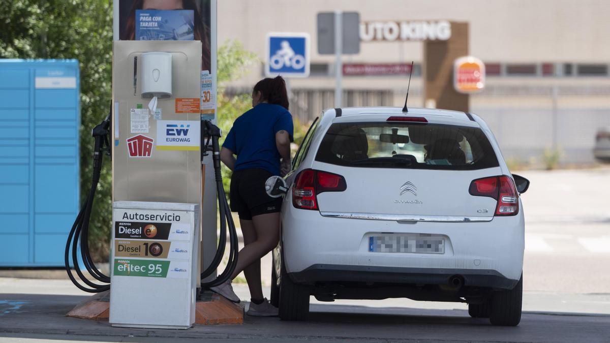 Una mujer reposta en una gasolinera.