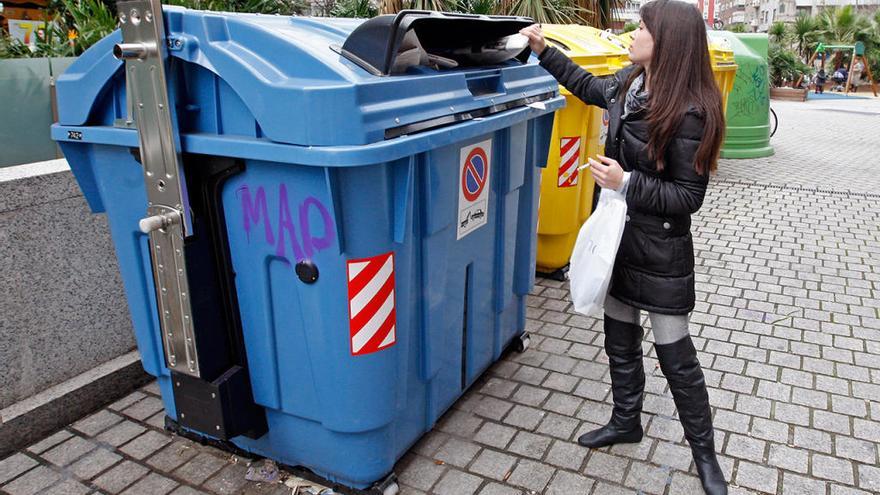 Una vecina de Vigo hace uso de un contenedor de reciclaje en Vigo // Marta G. Brea