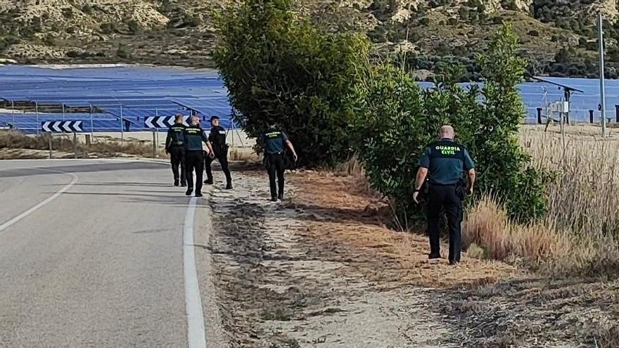 Agentes de la Guardia Civil buscan más restos en el arcén de una carretera en Xixona.