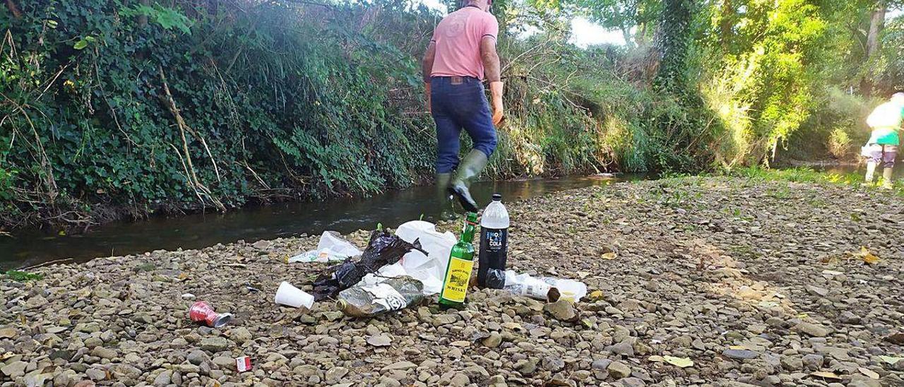 Restos de un botellón encontrados ayer en las aguas del río Noreña.