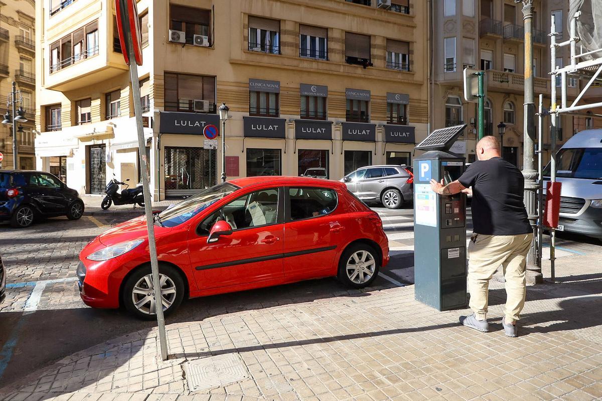 Un usuario saca su tiquet en el parquímetro.