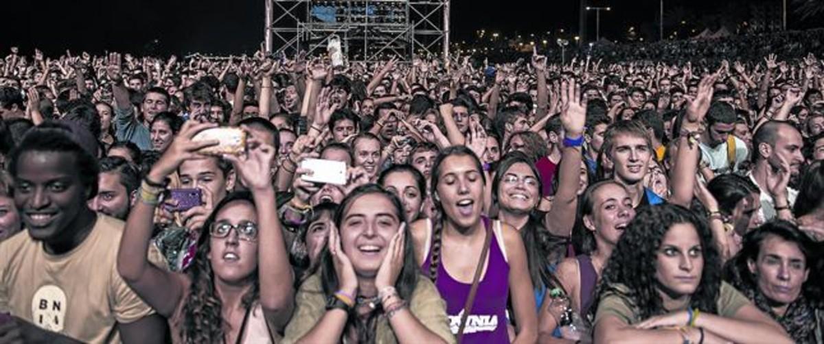 Centenares de jóvenes abarrotan la playa del Bogatell, durante un concierto de verano con motivo de las fiestas de la Mercè.