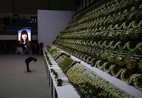 A woman pays tribute in Ansan, at a temporary group memorial altar for victims of capsized passenger ship Sewol