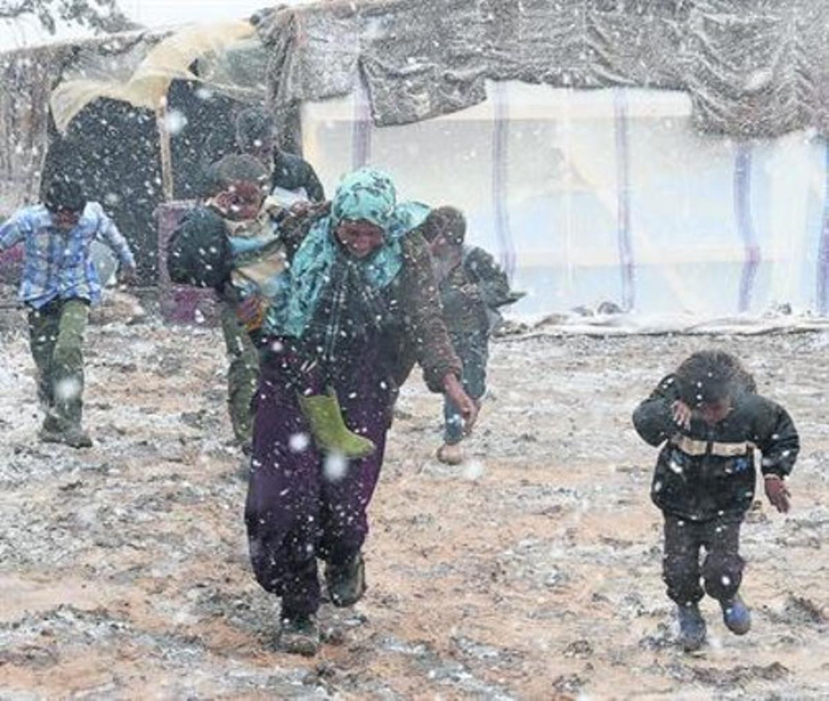 Una família siriana corre sota la neuen un camp de refugiats al Líban.