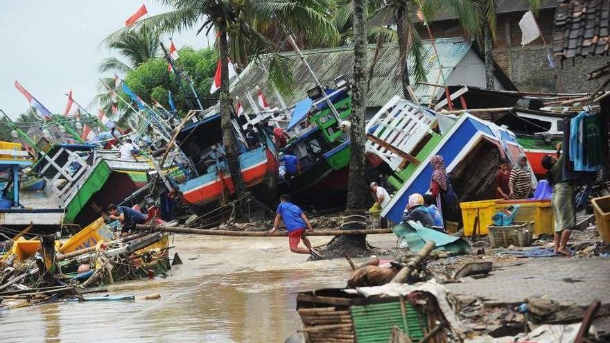 Pescadores de la zona afectada por el maremoto tratan de recuperar sus embarcaciones.