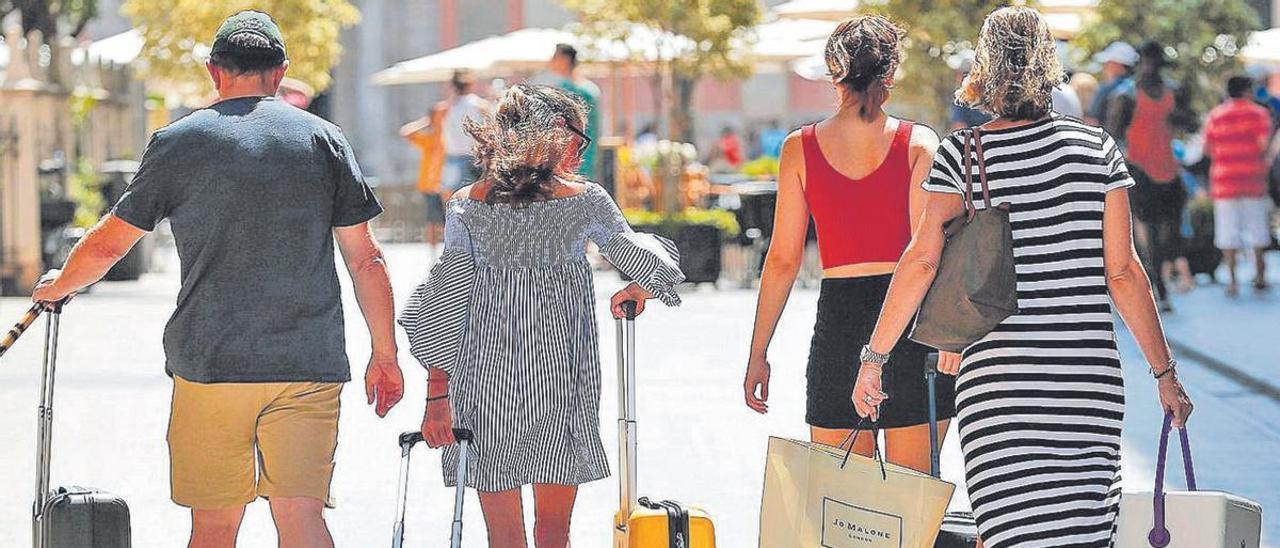 Una familia tira de sus maletas en una calle de Valencia.