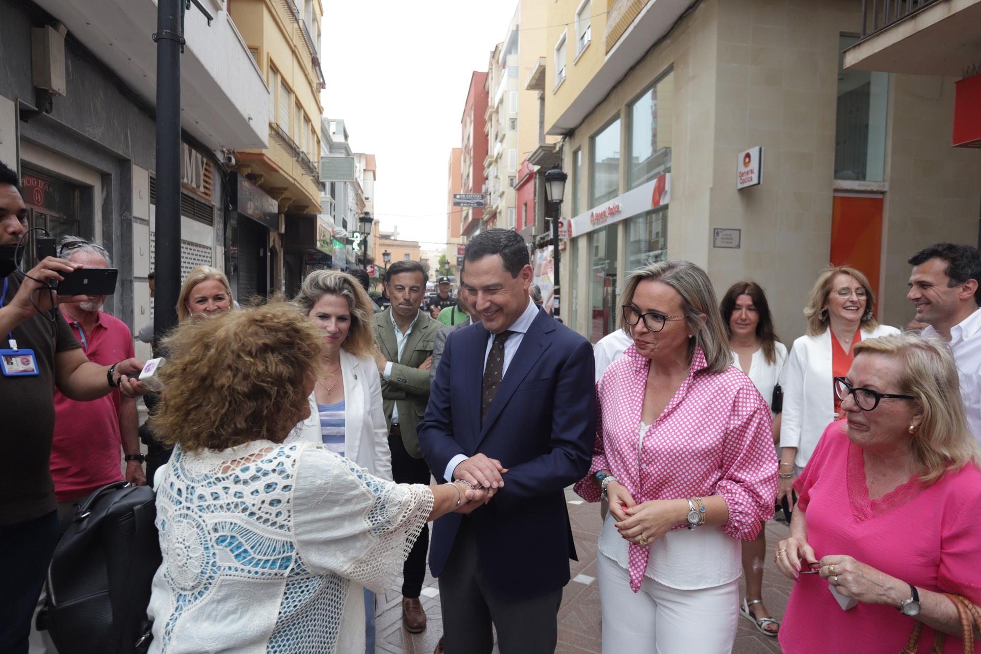 El presidente de la Junta de Andalucía y candidato a la reelección, Juanma Moreno (c), conversa con varias mujeres durante la visita realizada hoy a la Línea de la Concepción (Cádiz).