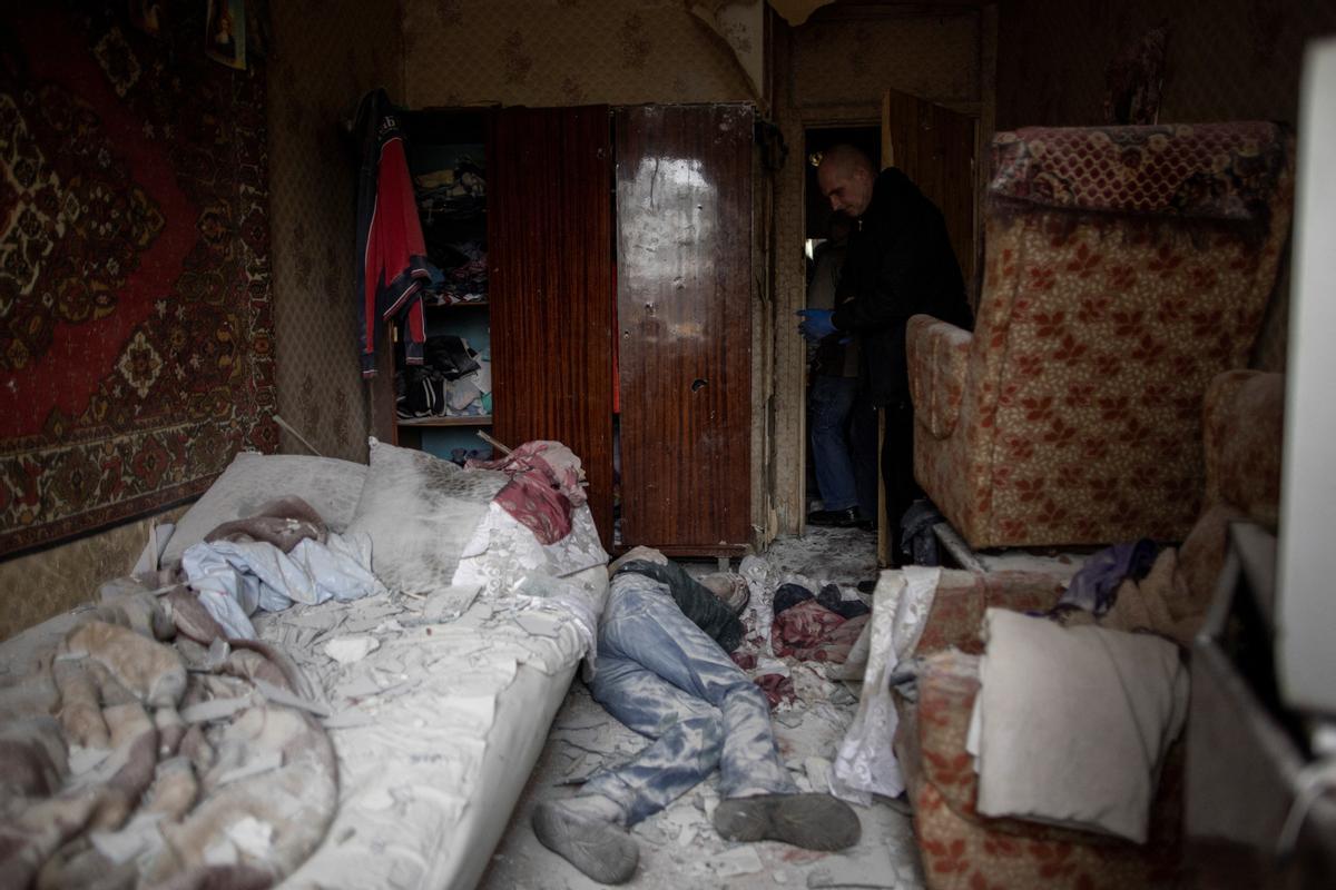 Un trabajador de emergencias se para sobre el cuerpo del residente local Sergiy, de 41 años, en su apartamento destruido, luego de un ataque de artillería, en medio del ataque de Rusia contra Ucrania, en Kharkiv, Ucrania.