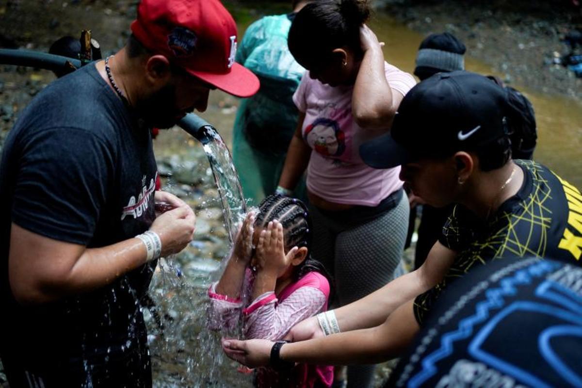 Migrantes cruzan el río Muerto en el Tapón del Darién, de viaje hacia los Estados Unidos, en Acandi, Colombia