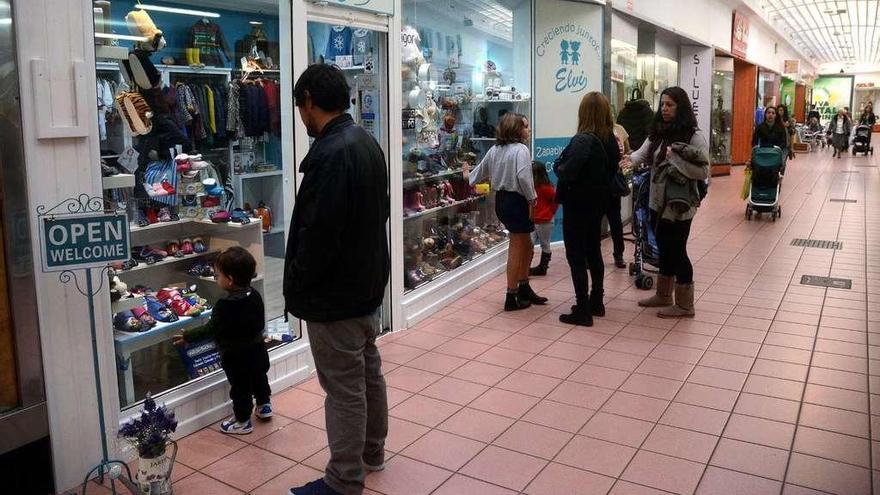 Varias personas en las galerías comerciales de la Oliva. // Rafa Vázquez