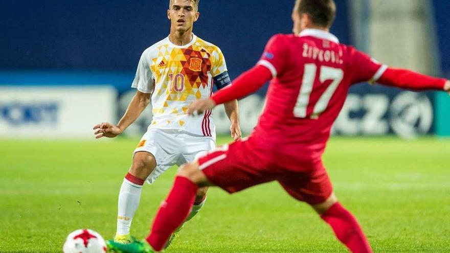 Denis Suárez toca el balón ante un defensa serbio.