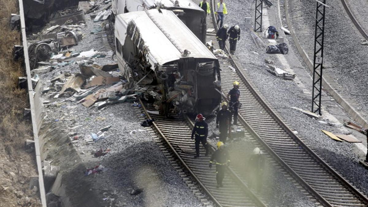 Operarios y bomberos trabajan en la curva donde tuvo lugar el accidente, el jueves en Santiago.