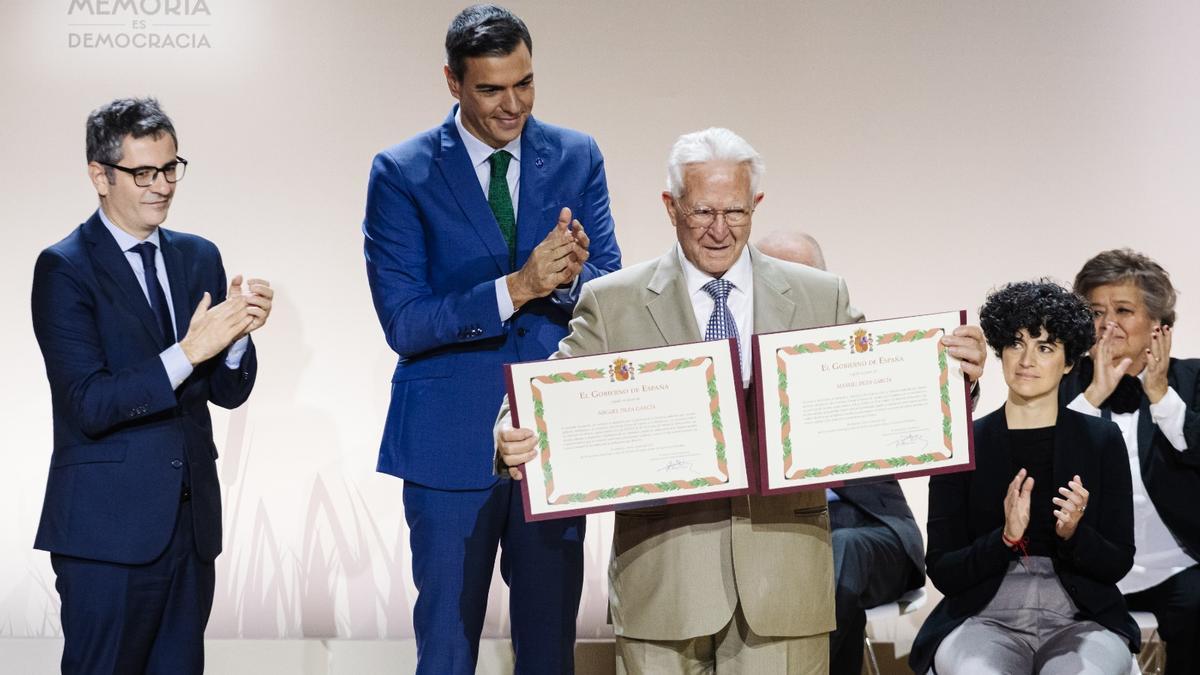 Antonio Deza sostiene los diplomas de reconocimiento de Miguel y Manuel Deza García, víctimas del franquismo. En la imagen, Pedro Sánchez y Félix Bolaños.