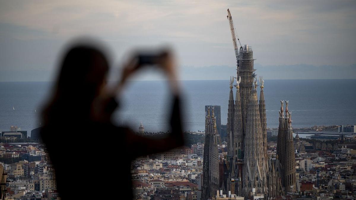Una dona fotografia la Sagrada Família, ahir. | JORDI COTRINA