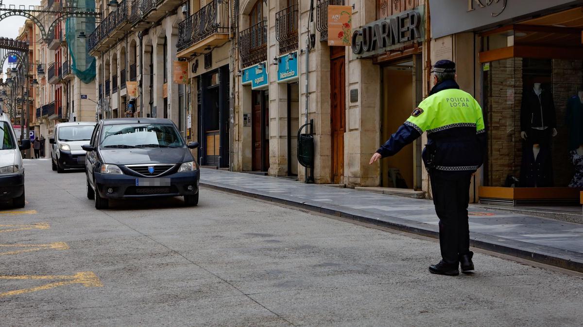 Un policía local dando el alto a un vehículo en la calle Sant Llorenç, principal vía objeto de peatonalización en el centro de Alcoy.