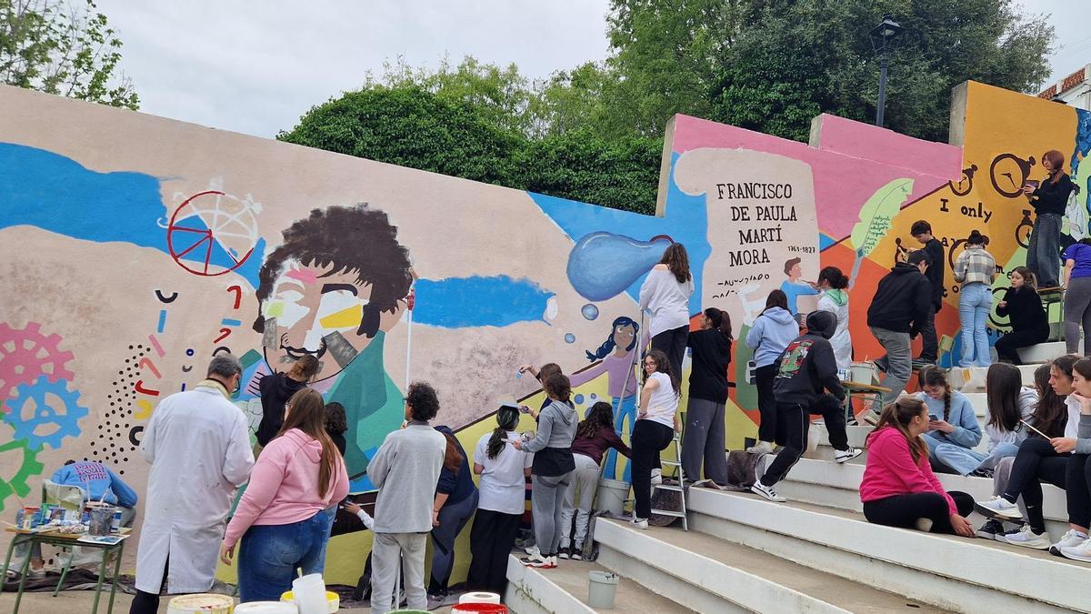 Alumnos de Bachillerato Artístico del IES Josep de Ribera pintando el mural en el colegio Taquígraf Martí.