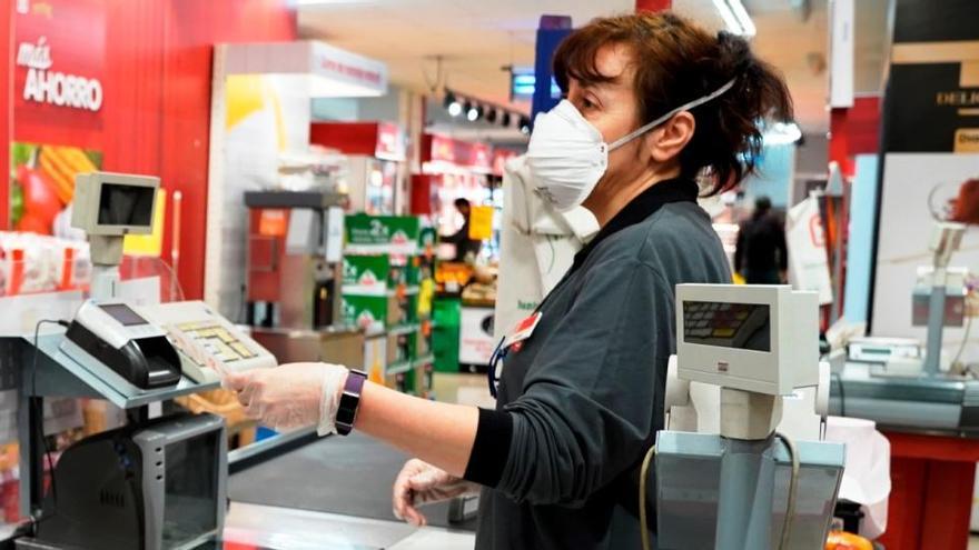 Una treballadora en un supermercat amb mascareta.