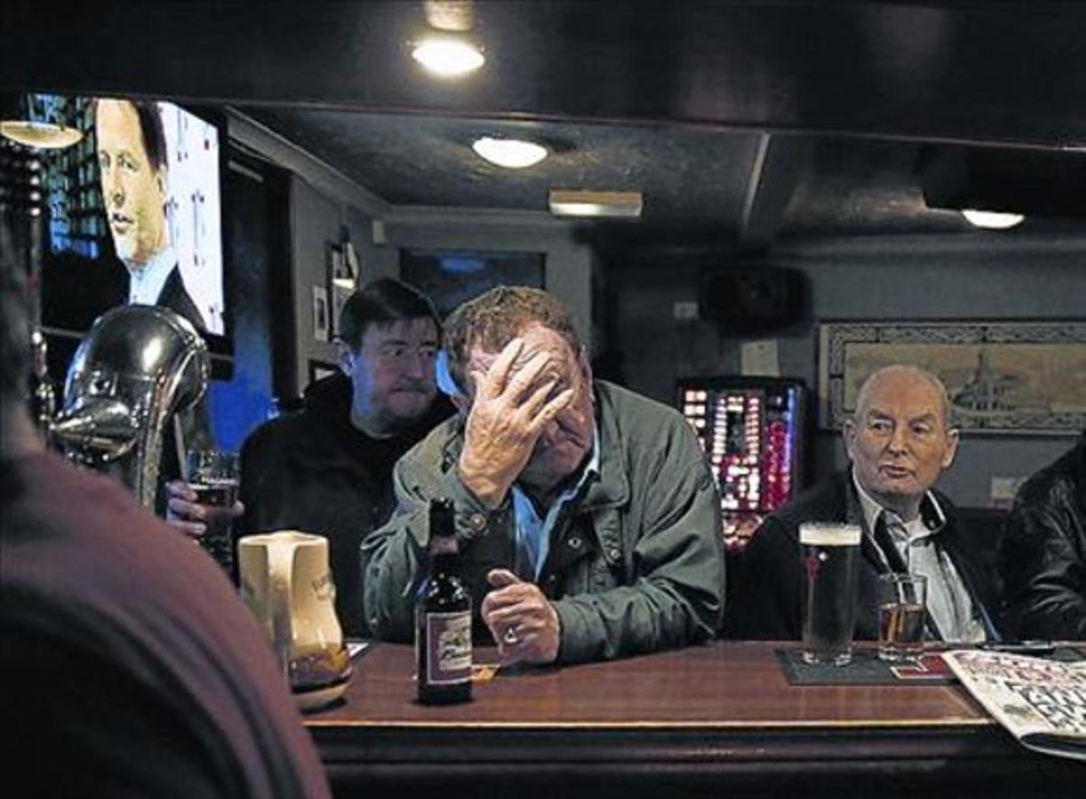 Clients d’un bar a Edimburg amb Nick Clegg a la televisió.