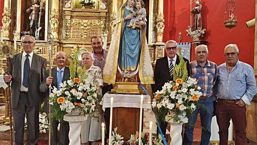 Junta directiva de la cofradía de la Virgen de la Salud, junto a la imagen de la patrona de Aliste.