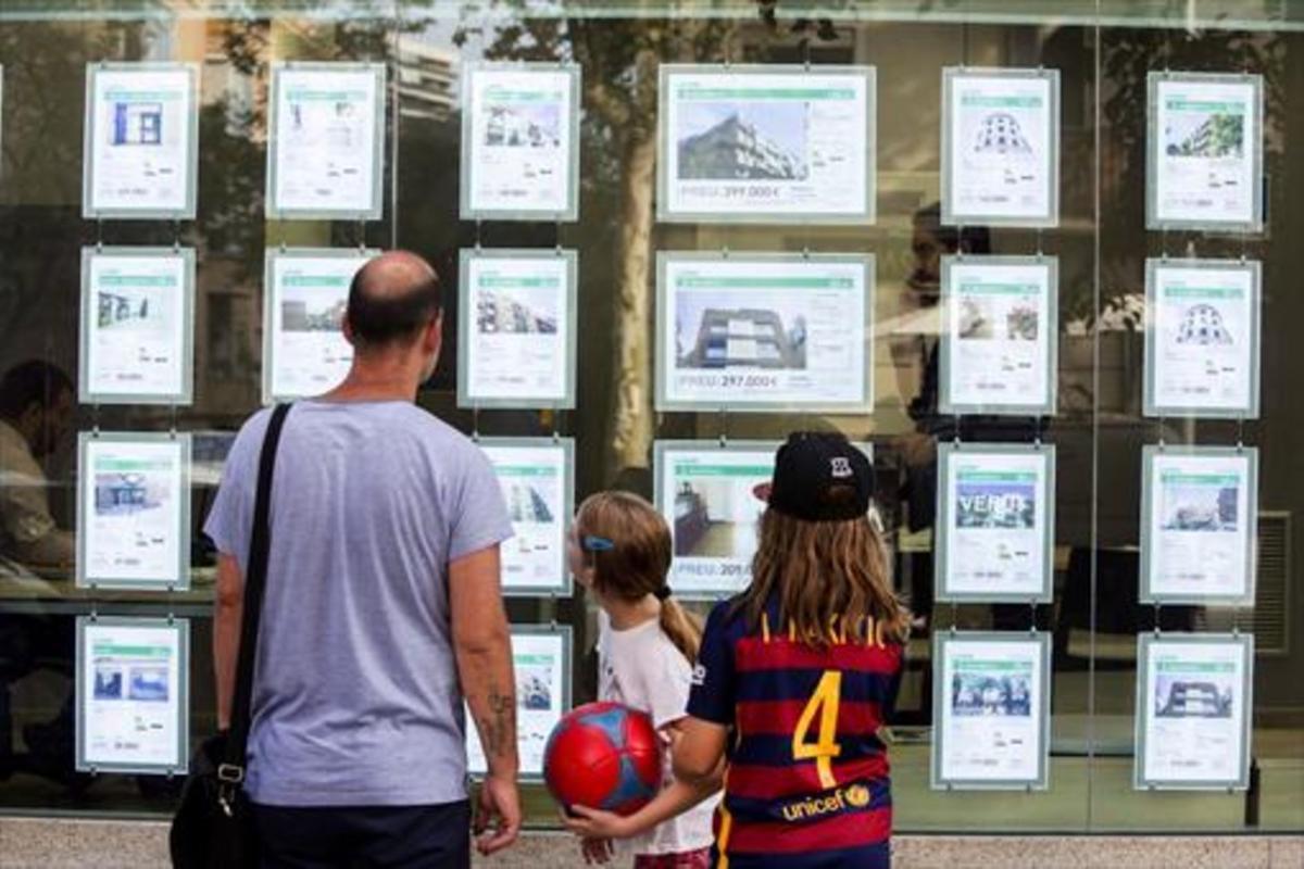 Una familia delante de una oficina inmobiliaria. 