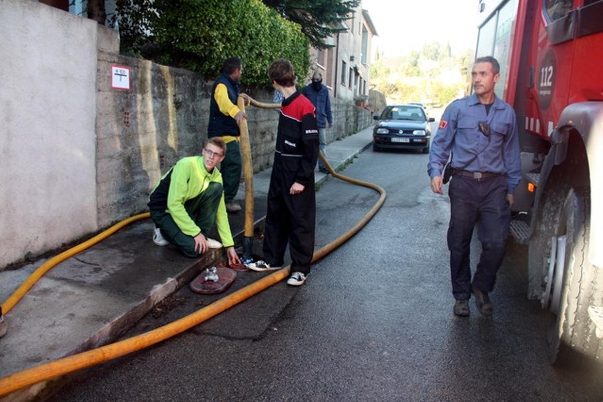 Veïns i voluntaris omplen cisternes d’aigua, aquest dimarts a Foixà.