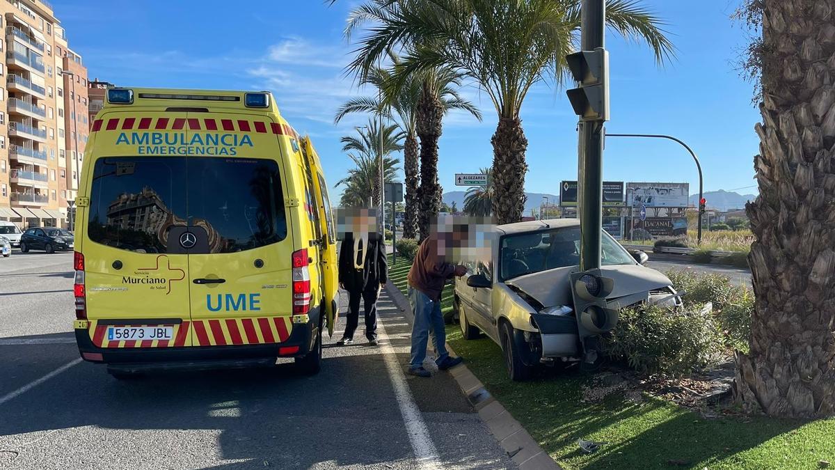 Ambulancia, en el lugar del suceso, con el coche estrellado.