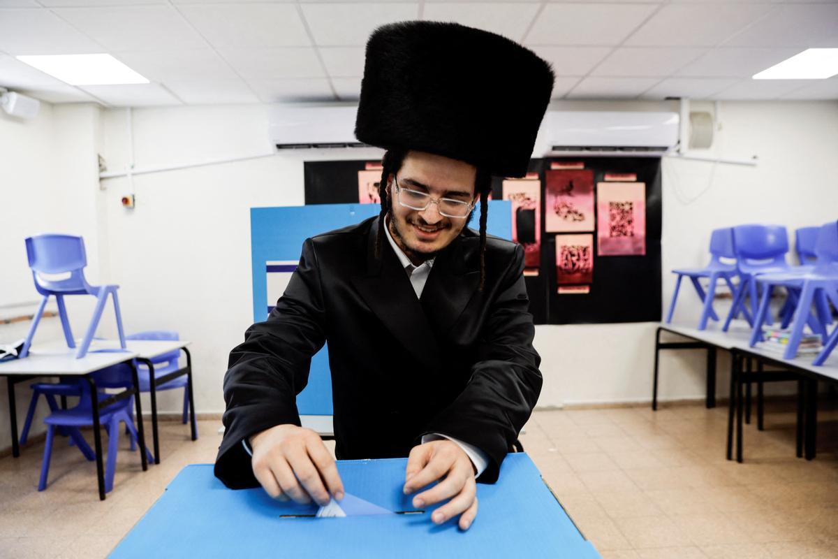 Un judío ultraortodoxo emite su voto durante las elecciones generales de Israel en un colegio electoral en Ashdod.
