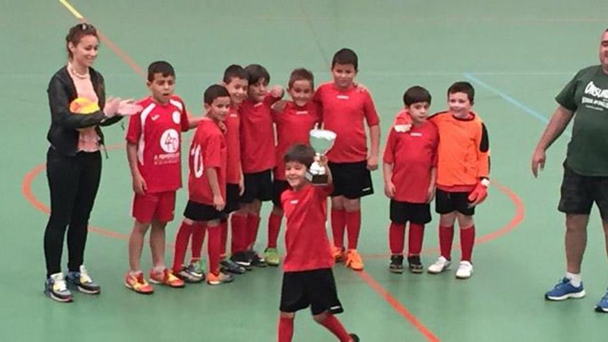 Los jugadores celebran su título con la copa de campeones.