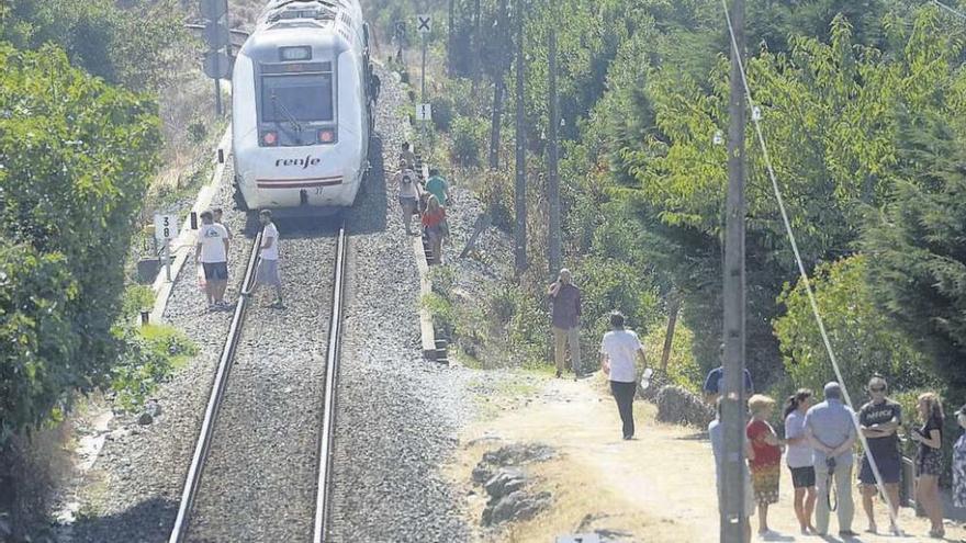 El tren involucrado en el accidente y algunos pasajeros cruzando la vía y en los alrededores. // Noé Parga