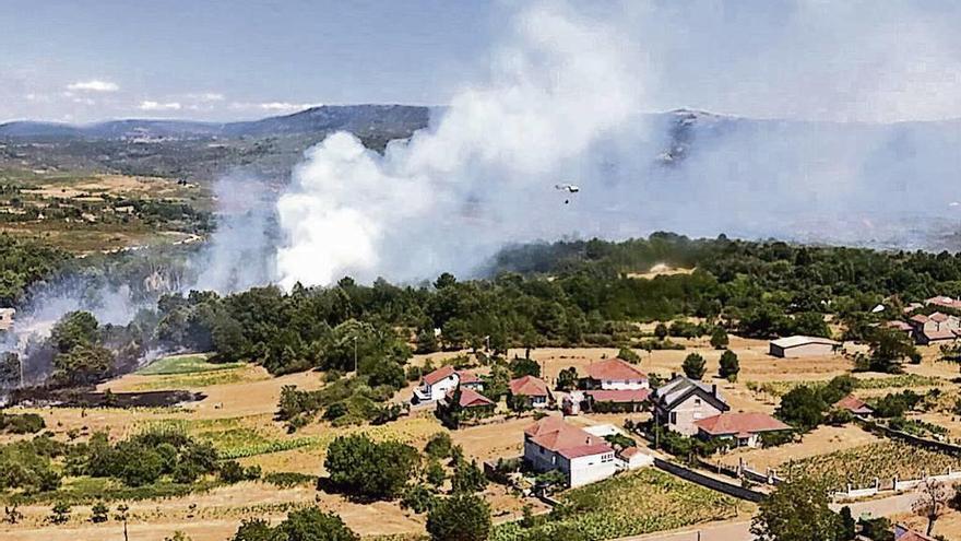 Un helicóptero participa en la lucha contra un fuego en Vilar de Cervos ayer. // Brif Laza