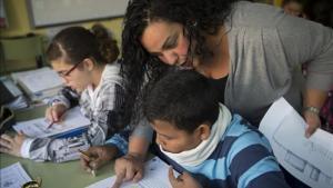 Una madre del colegio Joaquim Ruyra de L’Hospitalet ayuda como voluntaria a un alumno de sexto de primaria en una clase de Matemáticas.