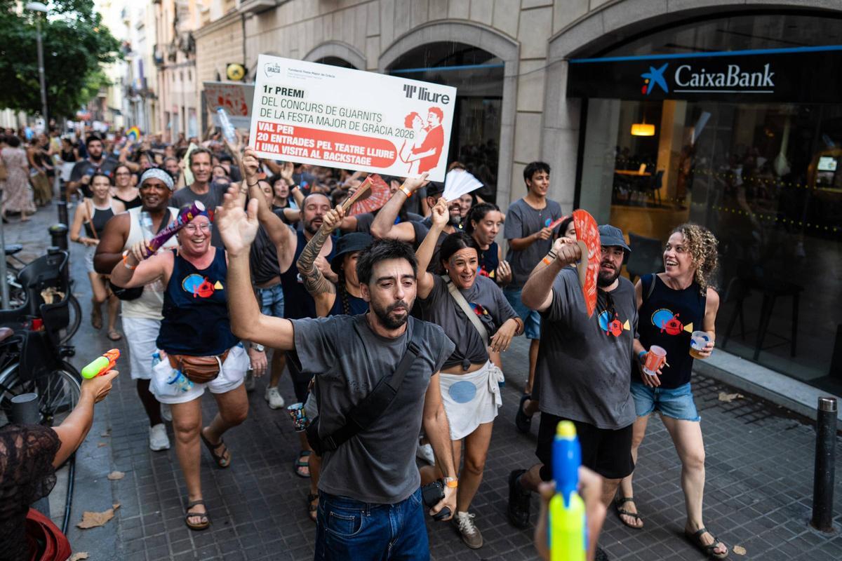 Vecinos y participantes celebran en la plaza Rovira el premio obtenido por su decoración durante la Festa Major de Gràcia