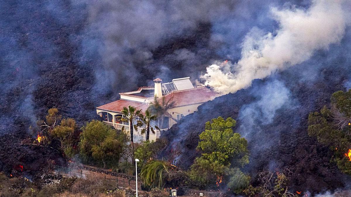 Imagen tomada desde un helicóptero por las coladas engullendo varias viviendas en La Palma. 