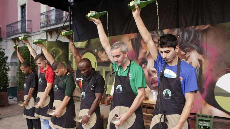 Por la derecha, Miguel Ferreira y Pablo Suárez echan un culín en la plaza Mayor con otros destacados escanciadores del campeonato local y regional.