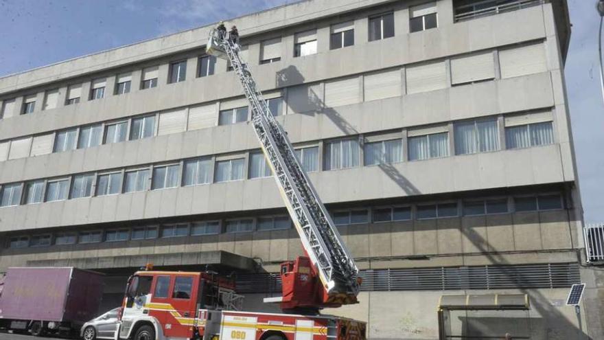 Los bomberos, durante la caída de cascotes del edificio de Sanidade, el pasado mes de abril.